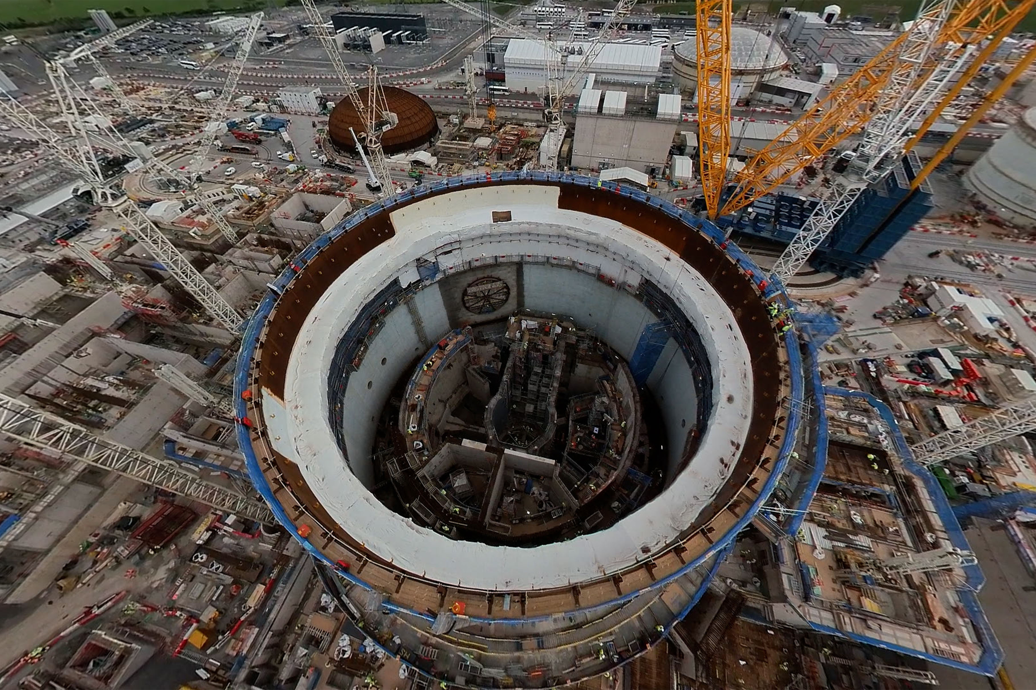 Large-scale energy infrastructure under construction with cranes and circular reactor structure — symbolising innovation and technology for clean energy transition.